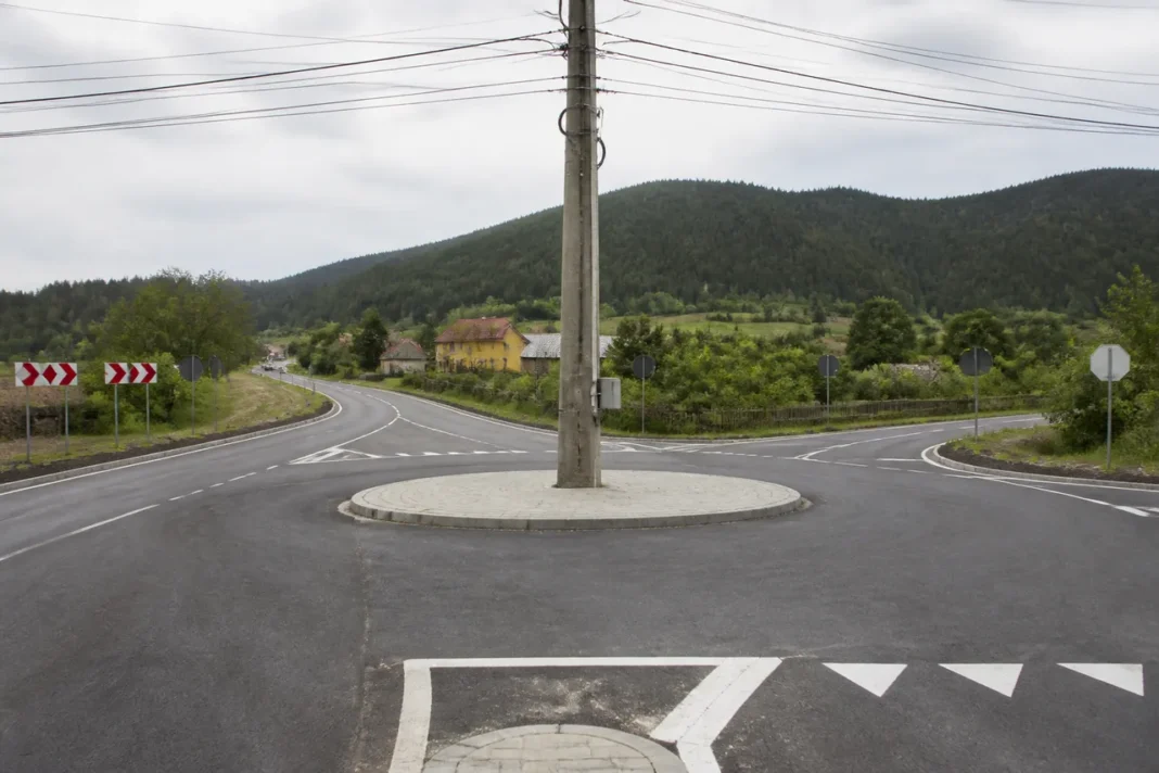 Stâlp de beton lăsat în mijlocul unui drum din Alba. Constructorii au făcut un sens giratoriu în jurul lui
